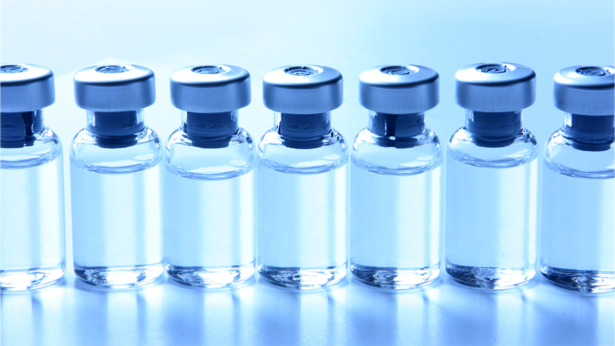 A line of vials containing clear liquid on a blue background.